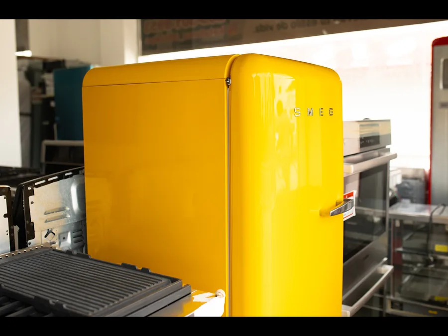Nevera Smeg amarilla en exhibición junto a otras marcas